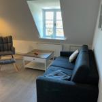 Living room with sofa, armchair, and window