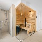 Dusche und Sauna in moderner Umgebung mit Holz und Glas.