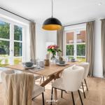 Esszimmer mit Holztisch, Stühlen und Blick auf Garten.