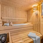 Holzsauna mit Sitzbänken, Steinen und Handtuch
