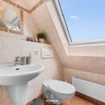 Badezimmer mit Waschbecken, Toilette und Dachfenster.