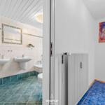 Badezimmer mit zwei Waschbecken und Toilette. Fliesenboden und Wandbild.