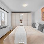 Schlafzimmer mit Bett, Kleiderschrank und Fenster mit Blick auf Schnee.