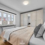 Schlafzimmer mit Bett, Kleiderschrank und Fenster.