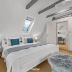 Schlafzimmer mit Dachschrägen, Dachfenster, Bett, Nachttische und Kleiderschrank.