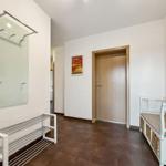 Flur mit Garderobe, Bänkchen und Tür. Wandbild und Bodenfliesen sichtbar.