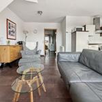 Wohnbereich mit Sofa, Sessel und Küchenzeile