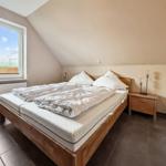 Schlafzimmer mit Doppelbett, Nachttisch und Fenster mit Blick.