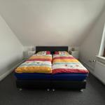 Schlafzimmer mit Doppelbett, Fenster und Heizung.