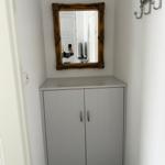 Eingangsbereich mit Spiegelschrank und Kleiderhaken an der Wand.