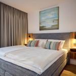 Schlafzimmer mit Doppelbett, Wandbild und Holznachttischen