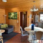 Wohnbereich mit Sofa, Esstisch und Küche in Holzhaus