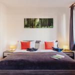 Schlafzimmer mit Doppelbett, zwei Nachttischen und Wandbild