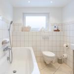 Badezimmer mit Badewanne, Toilette und Waschbecken.