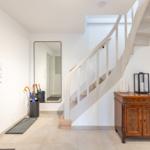 Eingang mit Treppe, Spiegel und Holzschränkchen