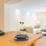 Essbereich mit Tisch und Stühlen, Wohnbereich mit Sofa und Couchtisch.