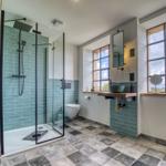 Badezimmer mit Dusche, Toilette und Waschtisch mit Fenster
