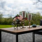 Hochwertiger Tisch mit Blumen und Kerzen auf Terrasse