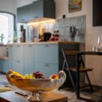 Küche mit Obstschale und Essbereich im Hintergrund.