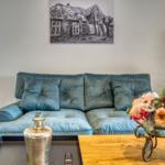 Ein Sofa mit Kissen, ein Tisch mit Blumen und eine Wanddekoration.