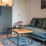 Wohnbereich mit Sofa, Tisch und Küchenzeile