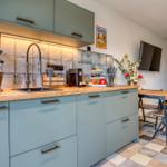 Küche mit Holzoberfläche, grauen Schränken und Küchenspüle.