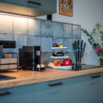 Küche mit Holzoberfläche, Edelstahlspüle und moderner Kochplatte.