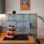 Küche mit Holzoberfläche, Steinwand und Fanta-Wandposter.