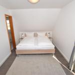 Schlafzimmer mit Doppelbett, Nachttischen und Fenster