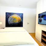 Schlafzimmer mit Bett, Wandbild und Fernseher an Wand.