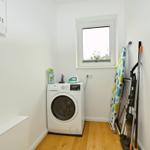 Wäscherei mit Waschmaschine, Fenster und Reinigungsmitteln.