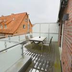 Terrasse mit Tisch und Stühlen, Blick auf ein roofgedecktes Haus.