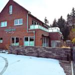 Apartmenthaus Emily mit Balkon, Schnee und Steinmauer.