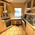 Küche mit Arbeitsplatten, Spüle, Herd und Fenster mit Blick.