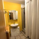 Badezimmer mit Waschbecken, Spiegel und Dusche.