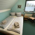 Ein Schlafzimmer mit einem Doppelbett, einem Stuhl und einem Fenster.