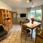 Esszimmer mit Holztisch, Stühlen und Küchenzeile. Durchgang zur Küche.