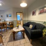 Wohn- und Essbereich mit Sofa, Tisch und Küchenansicht.