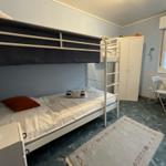 Zimmer mit Doppelstockbett, Schreibtisch und Kleiderschrank.