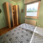 Schlafzimmer mit Bett, Kleiderschränken und Fenster.