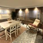 Esszimmer mit Tisch, Stühlen und Sessel. Wandbild zeigt Strand. Bodenfliesen und Tapete.