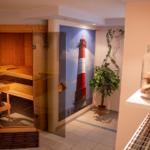 Sauna mit Holzbank und Wandbild eines Leuchtturms.