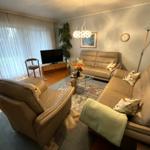 Wohnzimmer mit Ledersofa, Glas-Tisch und Fernseher