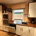 Küche mit Spüle, Waschmaschine und Fenster