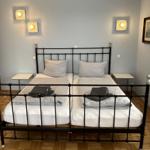 Zimmer mit Doppelbett, zwei Nachttischen und Wandlampen.