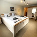 Schlafzimmer mit Doppelbett, Kleiderschrank und Nachttisch.