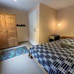 Schlafzimmer mit Bett, Kleiderschrank und Spielteppich.