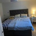 Schlafzimmer mit Bett, Nachttisch und Lampen.
