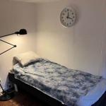 Ein Schlafzimmer mit einem Bett, einer Stehlampe und einer Wanduhr.