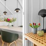 Dining area with table and chairs, living area with table, lamp, and flowers.